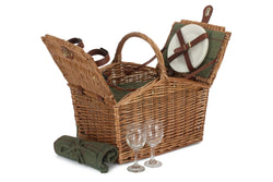 Wicker picnic basket with cutlery set, blanket, and wine glasses on a white background