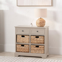 Putty pine storage unit with banana leaf baskets, drawers and a lamp in a room setting